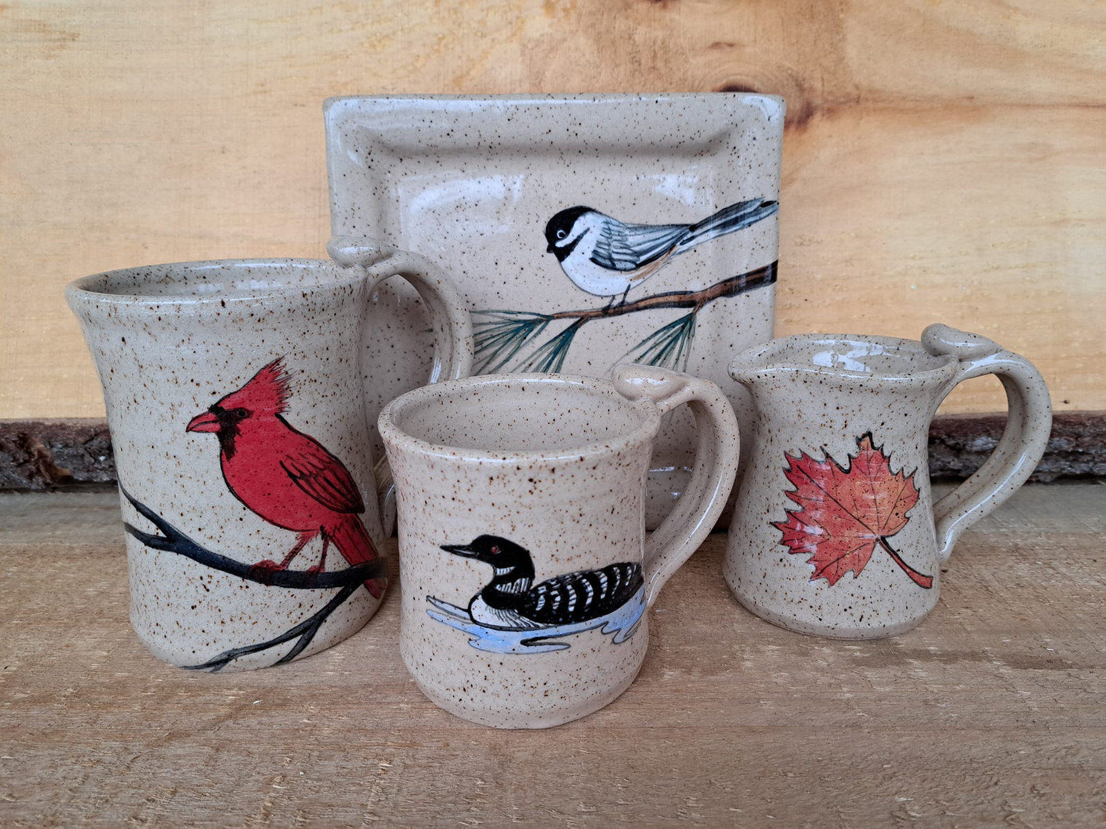 Hand-painted songbird and maple leaf pottery